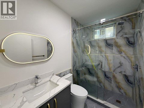 A bathroom with marble countertops and a walk-in shower.