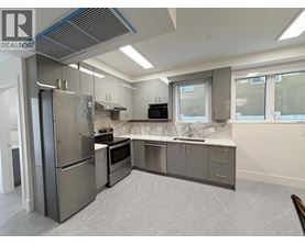 A modern kitchen with stainless steel appliances and marble flooring.