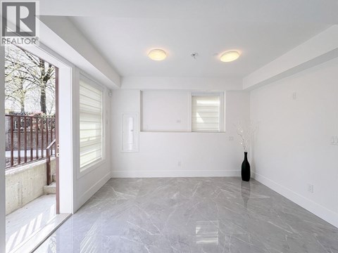 A room with a marble floor and a vase on the floor.