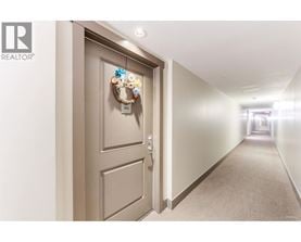 A hallway with a door on the left and a wreath on the door.