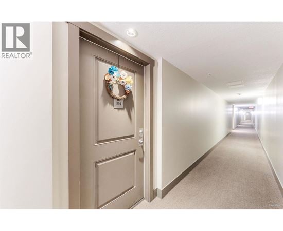A hallway with a door on the left and a wreath on the door.
