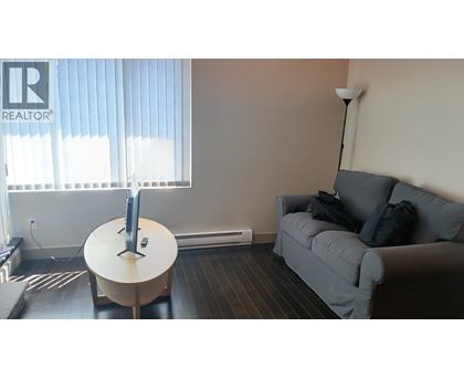 A living room with a grey couch and a white table.