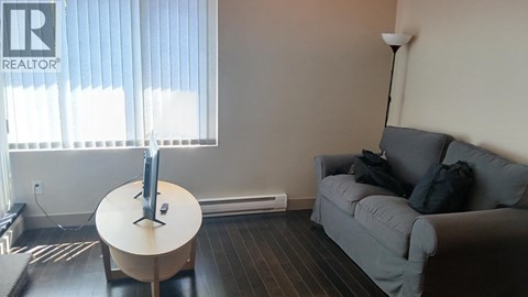 A living room with a grey couch and a white table.
