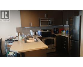 A kitchen with a sink, stove, and refrigerator.