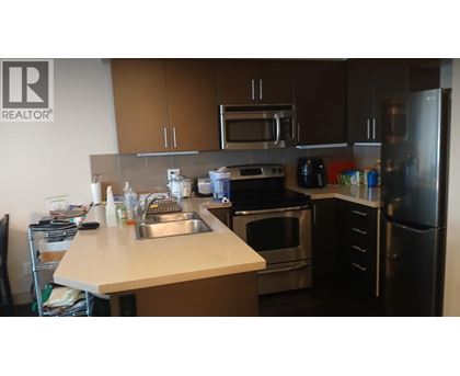 A kitchen with a sink, stove, and refrigerator.