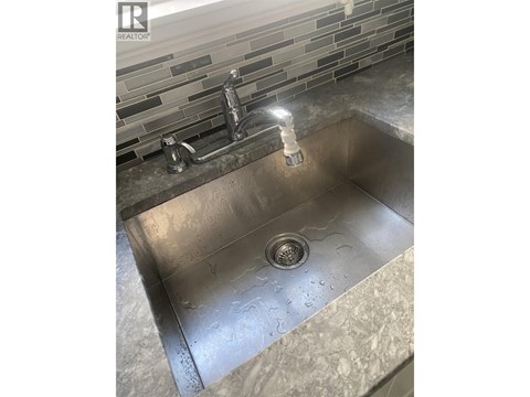 A sink with a faucet and a drain in the middle.