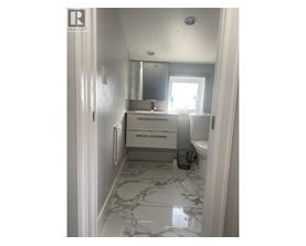 A bathroom with a marble floor and white walls.
