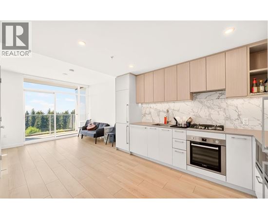 A modern kitchen with a marble backsplash and wooden flooring.