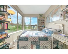 A bedroom with a bed, desk, and bookshelf.