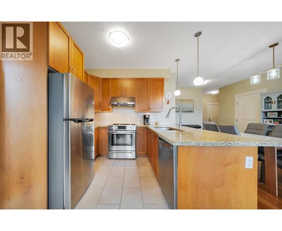 A kitchen with wooden cabinets and a stainless steel refrigerator.