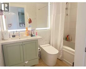 A bathroom with a toilet, sink, and bathtub.