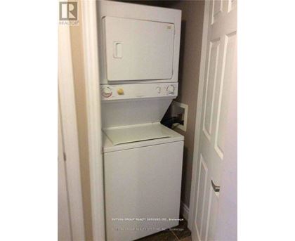 A white dishwasher and dryer are stacked in a small space.
