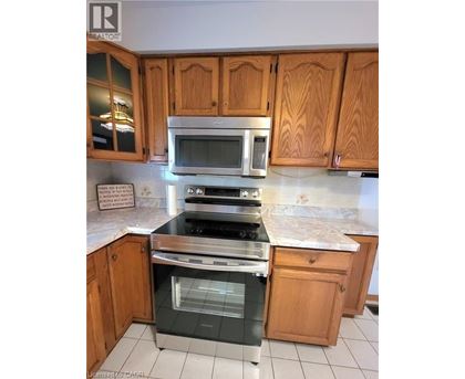A kitchen with wooden cabinets and a stainless steel oven.