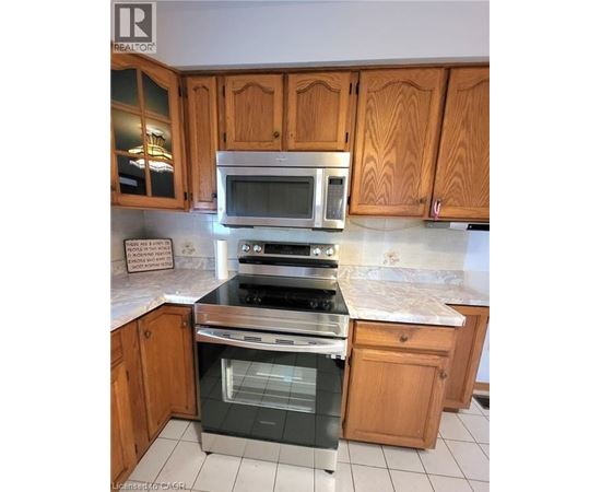 A kitchen with wooden cabinets and a stainless steel oven.