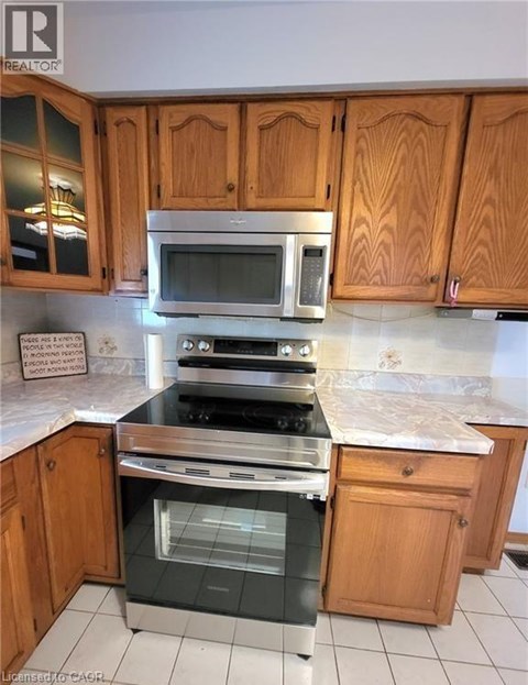 A kitchen with wooden cabinets and a stainless steel oven.