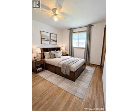 A bedroom with a bed, nightstands, and pictures on the wall.