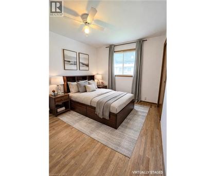 A bedroom with a bed, nightstands, and pictures on the wall.