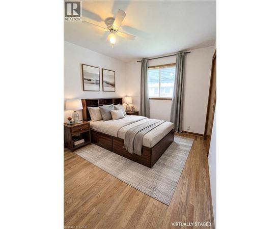 A bedroom with a bed, nightstands, and pictures on the wall.