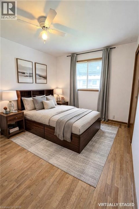 A bedroom with a bed, nightstands, and pictures on the wall.