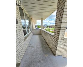 A long concrete walkway between two brick walls.