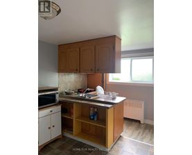 A kitchen with wooden cabinets and a tile floor.