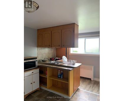 A kitchen with wooden cabinets and a tile floor.