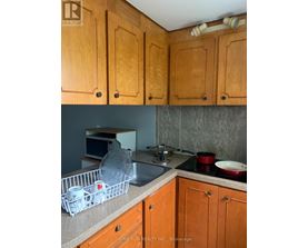 A kitchen with wooden cabinets and a sink.