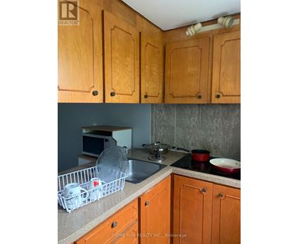 A kitchen with wooden cabinets and a sink.