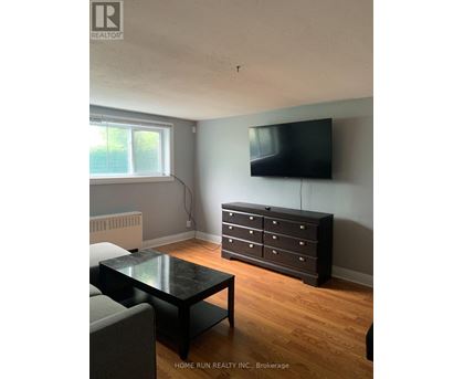 A black coffee table sits in front of a grey couch in a living room.