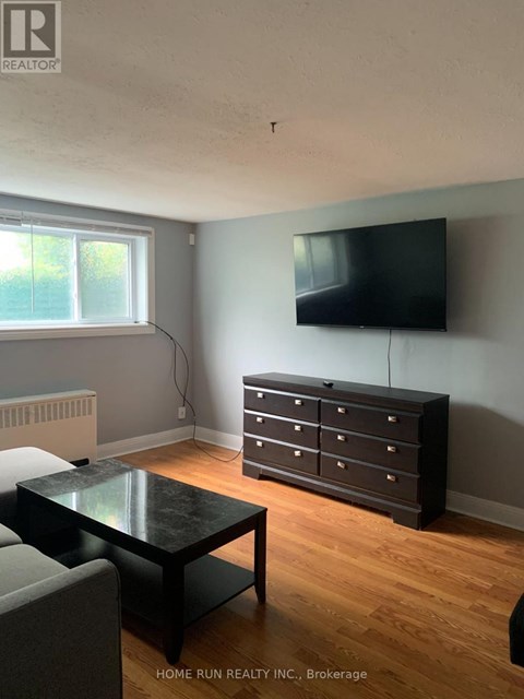 A black coffee table sits in front of a grey couch in a living room.
