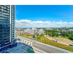 A view from a high-rise building looking out over a cityscape with a bridge and railway tracks.