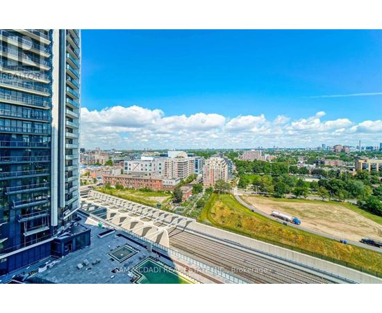 A view from a high-rise building looking out over a cityscape with a bridge and railway tracks.