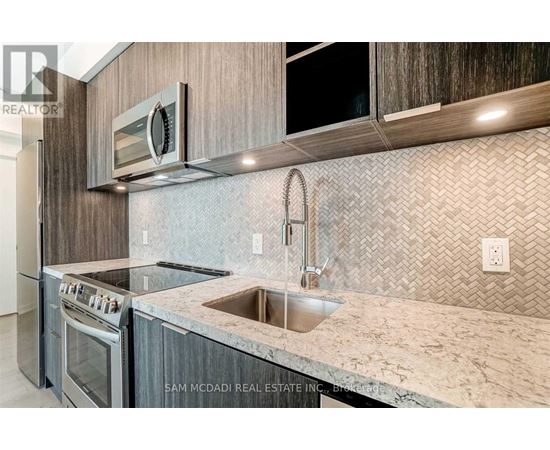 A kitchen with a granite countertop and a stainless steel sink.