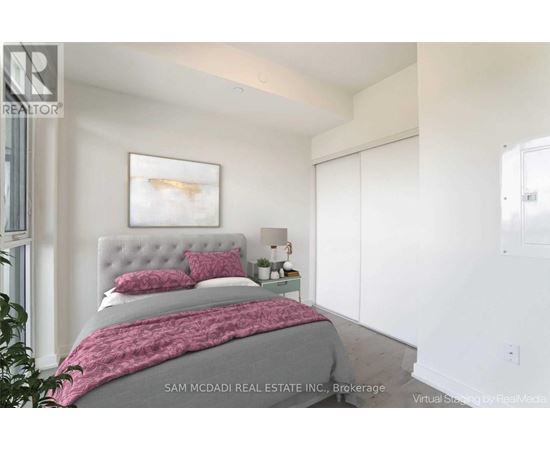 A bedroom with a bed, a nightstand, and a painting on the wall.
