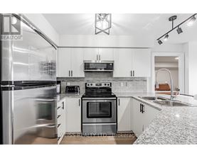 A modern kitchen with white cabinets and stainless steel appliances.