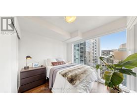 A bedroom with a large bed and a view of the city.
