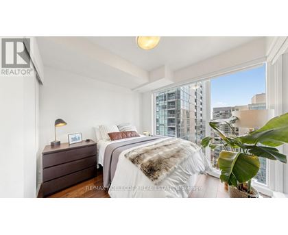 A bedroom with a large bed and a view of the city.