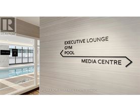 A sign in a hallway points to the Executive Lounge, Gym, Pool, and Media Centre.