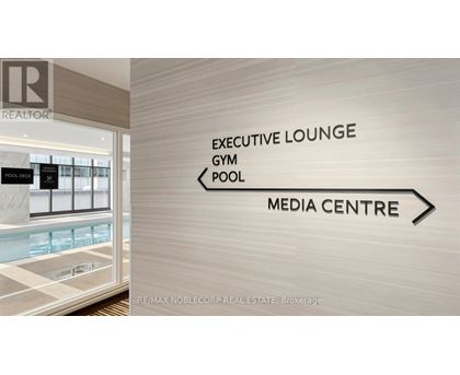 A sign in a hallway points to the Executive Lounge, Gym, Pool, and Media Centre.