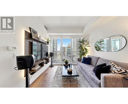 A living room with a grey couch and a coffee table in front of a large window.