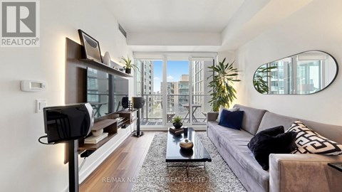 A living room with a grey couch and a coffee table in front of a large window.