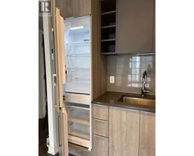 A kitchen with a refrigerator and a sink.