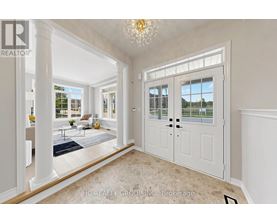 A spacious room with a chandelier, a door, and a view of the outside.