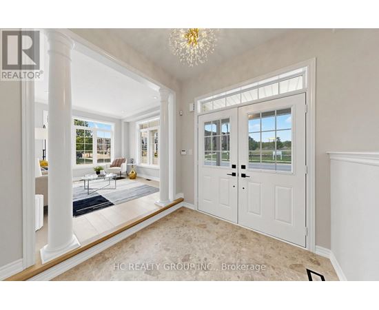 A spacious room with a chandelier, a door, and a view of the outside.