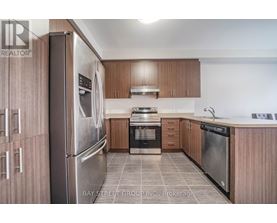 A modern kitchen with wooden cabinets and stainless steel appliances.