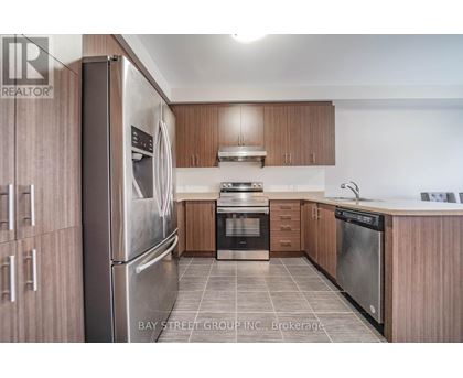 A modern kitchen with wooden cabinets and stainless steel appliances.