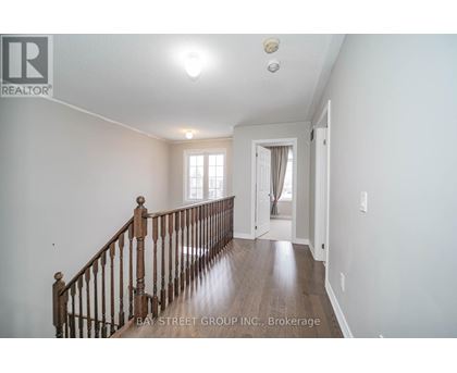 A spacious room with a wooden staircase leading to the second floor.