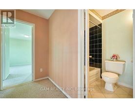 A white toilet sits in a bathroom with a glass shower door.