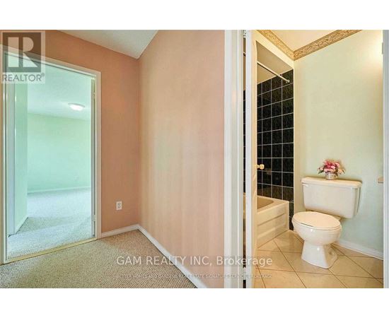 A white toilet sits in a bathroom with a glass shower door.