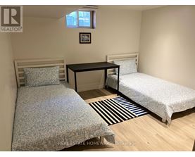 A bedroom with two beds and a desk.